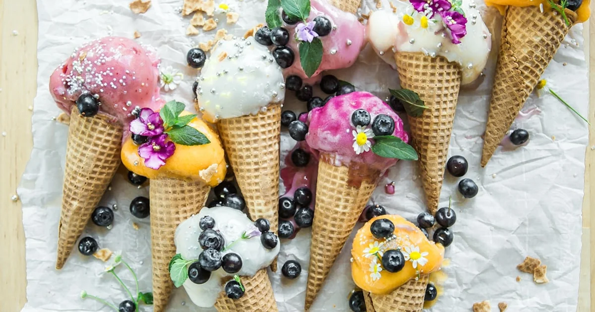 Ice cream scoops in waffle cones with tropical backdrop