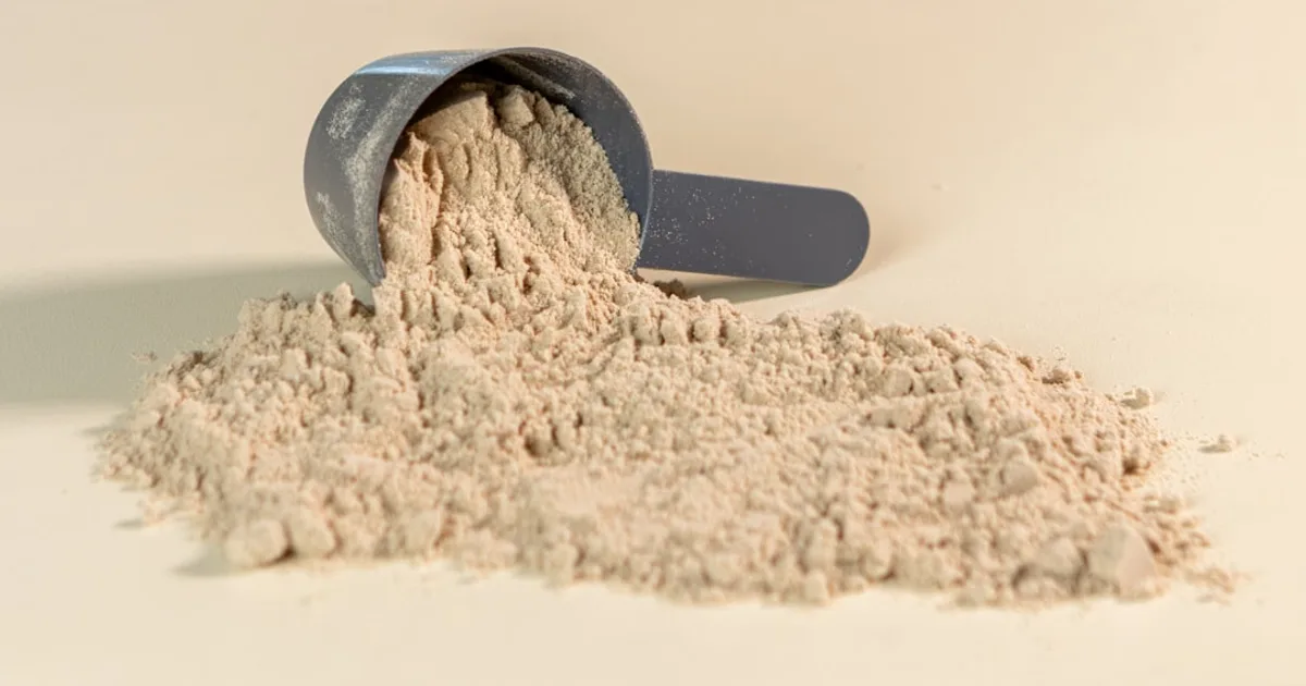 Protein powder tubs and a shaker bottle on a gym bench