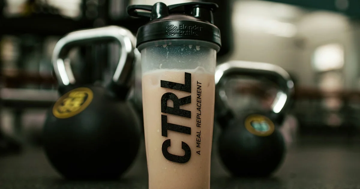 Protein powder scoop and shaker bottle on a bench