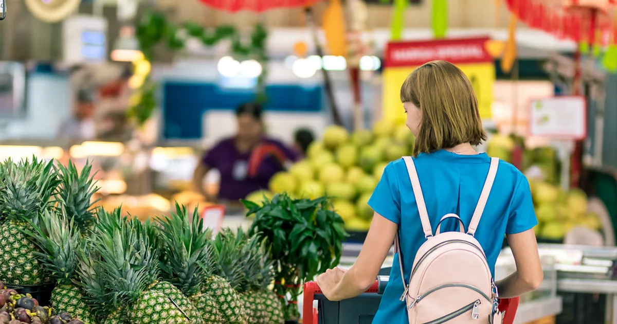 Person checking food label in supermarket aisle using the halal verification method